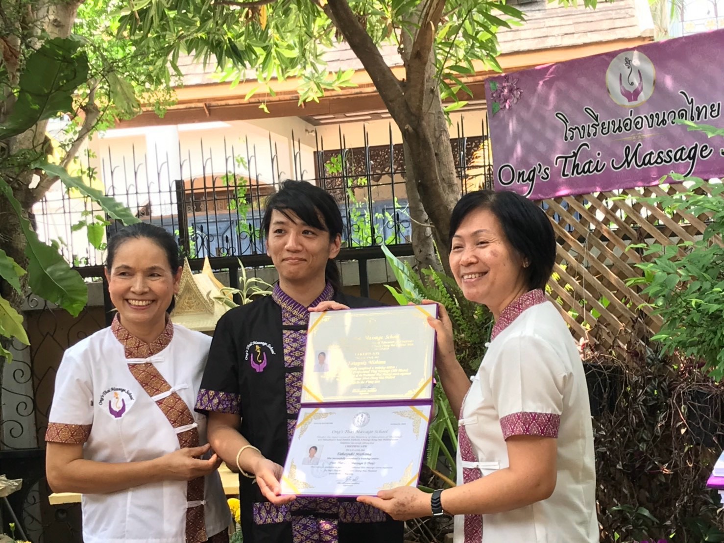 Ong's Thai Massage School の先生方と修了証を手にする本人